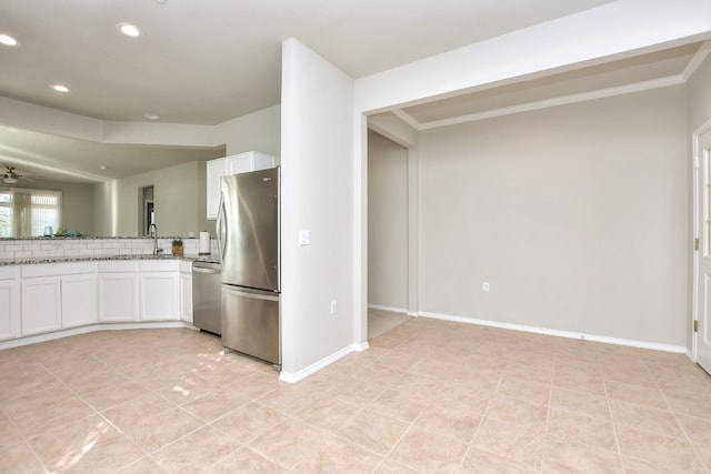 kitchen featuring appliances with stainless steel finishes, ornamental molding, white cabinets, and ceiling fan