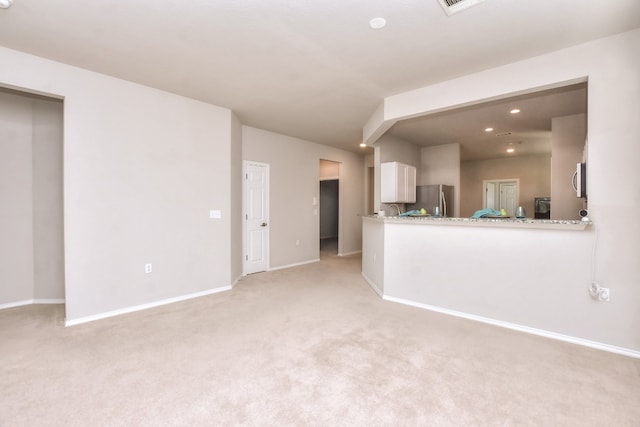 unfurnished living room featuring light carpet