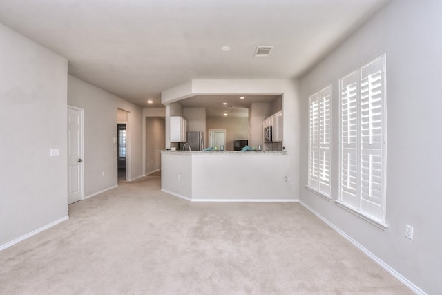 unfurnished living room with light colored carpet