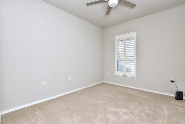 spare room with light colored carpet and ceiling fan