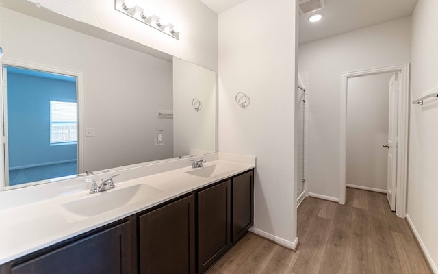 bathroom with vanity, hardwood / wood-style flooring, and a shower