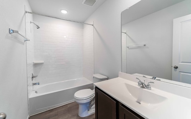 full bathroom with vanity, toilet, tiled shower / bath combo, and hardwood / wood-style floors