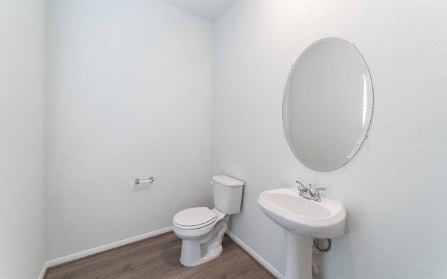 bathroom with toilet and wood-type flooring