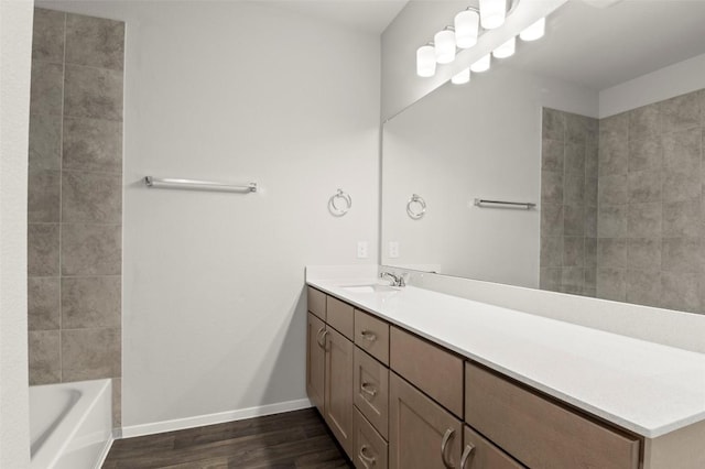 196 Lavender Ln, Elgin, TX 78621 - full bath with a tub, vanity, baseboards, and wood finished floors
