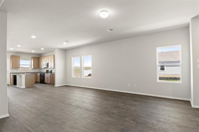 196 Lavender Ln, Elgin, TX 78621 - unfurnished living room featuring baseboards, visible vents, and a healthy amount of sunlight