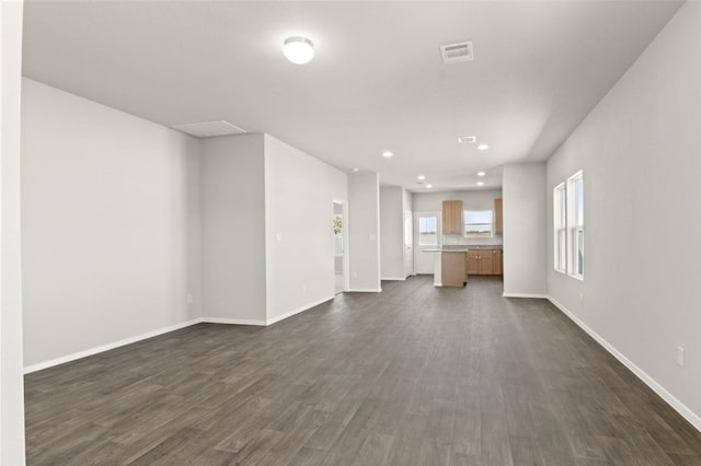 196 Lavender Ln, Elgin, TX 78621 - unfurnished living room with dark wood-type flooring, baseboards, visible vents, and recessed lighting
