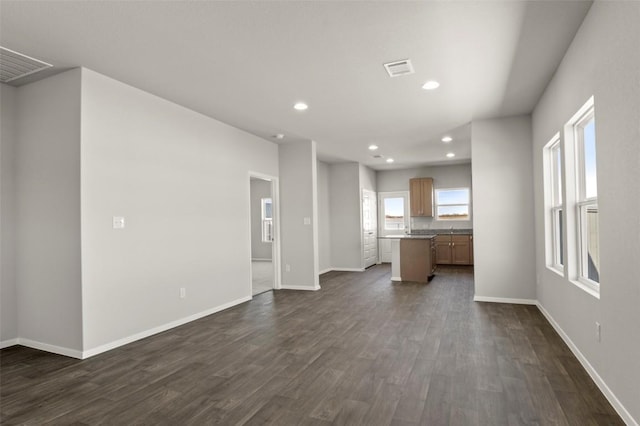 196 Lavender Ln, Elgin, TX 78621 - unfurnished living room featuring dark wood-style flooring, visible vents, baseboards, and recessed lighting