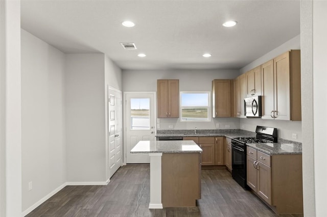 196 Lavender Ln, Elgin, TX 78621 - kitchen with light stone counters, dark wood finished floors, baseboards, black range with gas cooktop, and recessed lighting
