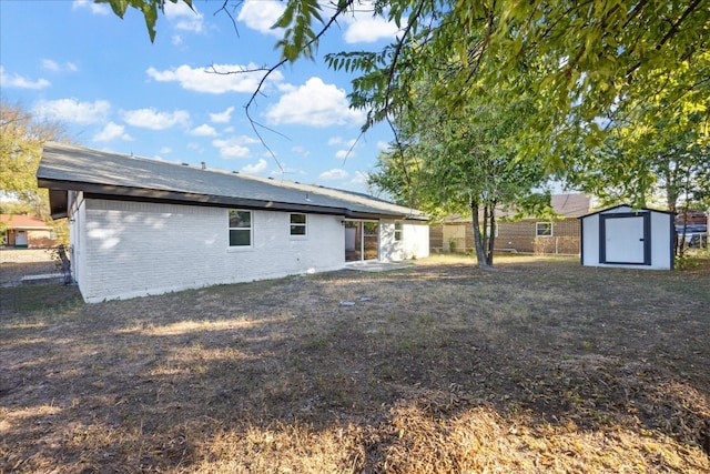 back of house with a storage unit