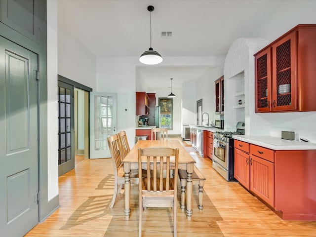 dining room with sink, light hardwood / wood-style floors, and french doors