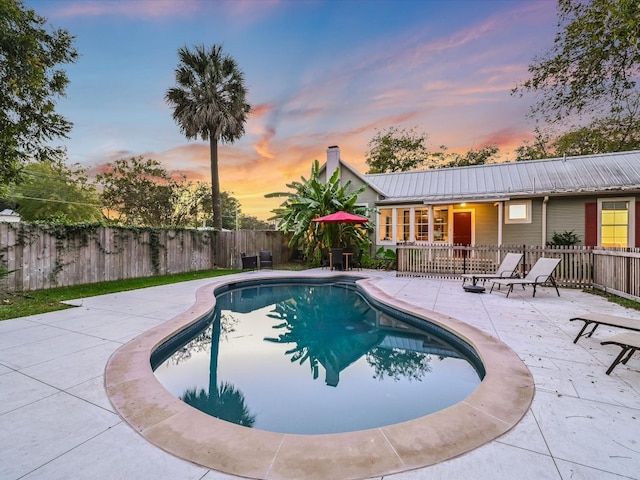 pool at dusk with a patio