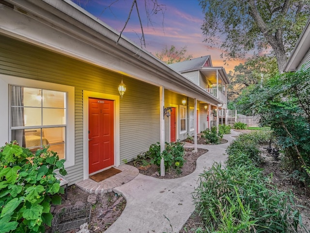 exterior entry at dusk featuring covered porch