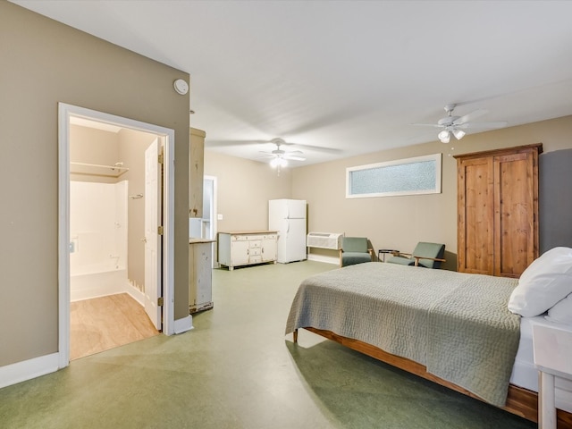 bedroom with concrete floors, ensuite bathroom, ceiling fan, and white refrigerator