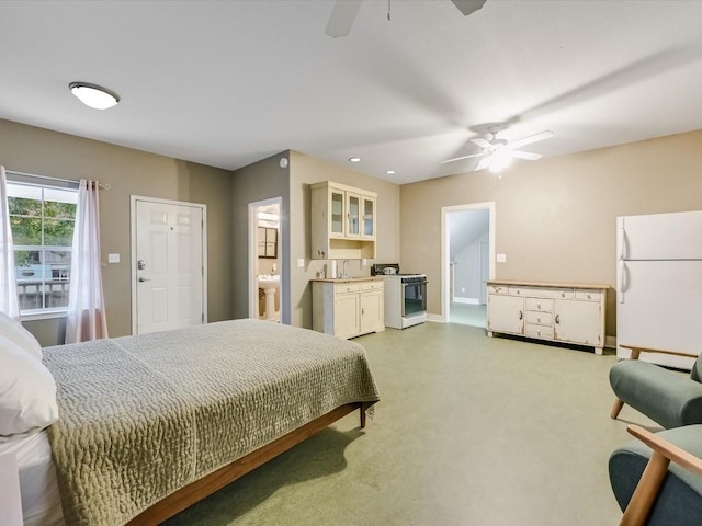 bedroom featuring a ceiling fan, a sink, baseboards, freestanding refrigerator, and light carpet