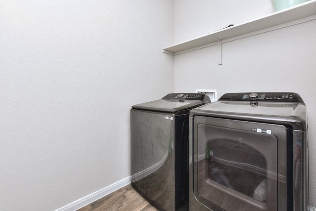 clothes washing area with independent washer and dryer and dark hardwood / wood-style flooring