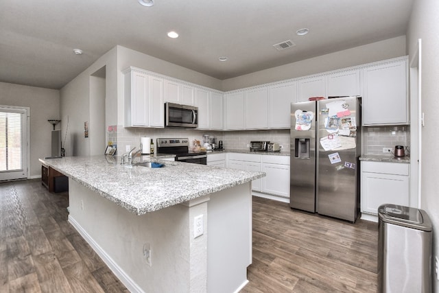 kitchen with sink, stainless steel appliances, dark hardwood / wood-style floors, kitchen peninsula, and white cabinets