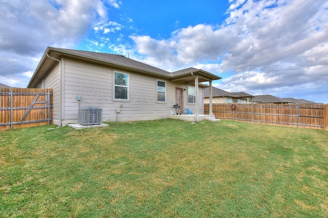 back of property featuring a lawn and cooling unit