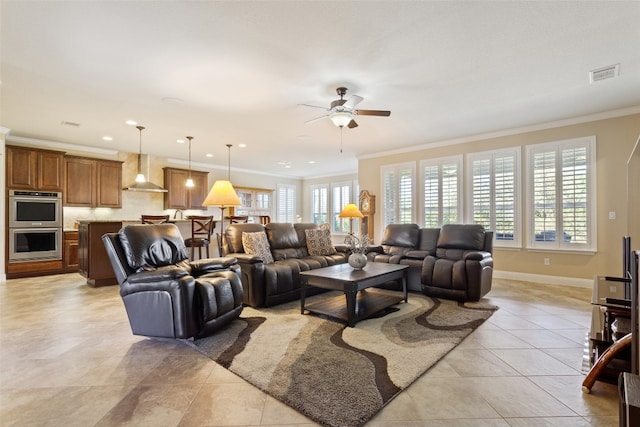 tiled living room with ornamental molding and ceiling fan