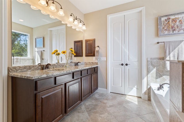 bathroom with vanity, a bathtub, and tile patterned flooring