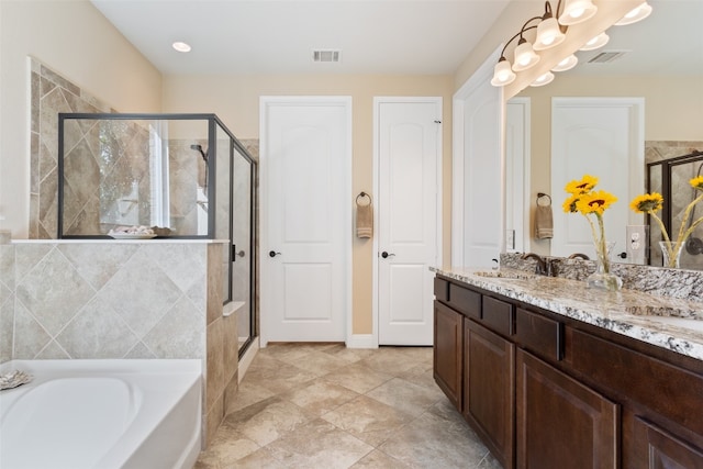 bathroom with vanity and shower with separate bathtub