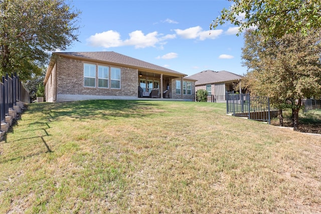 rear view of property featuring a yard and a patio