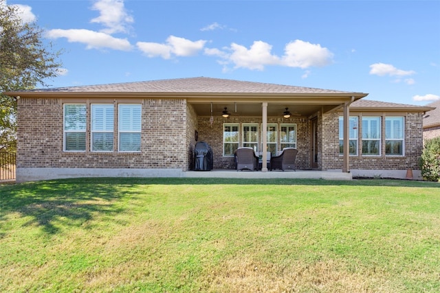 back of property with ceiling fan, a lawn, and a patio area