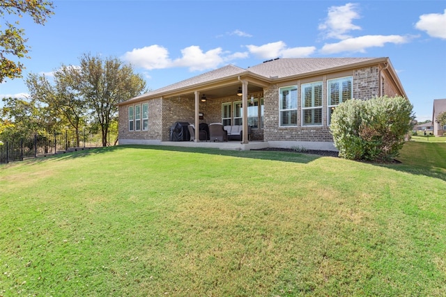 back of house with a patio area, a lawn, and ceiling fan