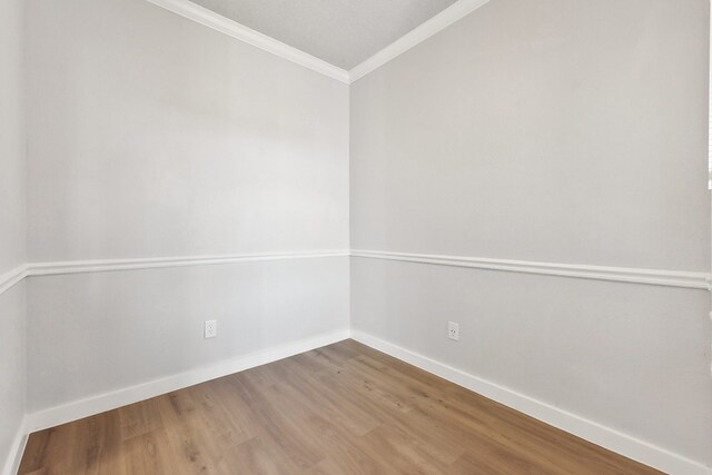 unfurnished room with ornamental molding and hardwood / wood-style flooring