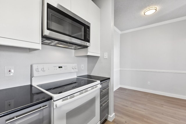 kitchen with ornamental molding, white cabinets, a textured ceiling, light hardwood / wood-style floors, and electric stove