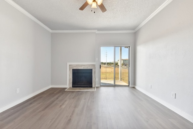 unfurnished living room featuring ceiling fan, hardwood / wood-style flooring, a textured ceiling, and ornamental molding