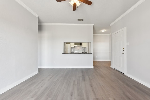 unfurnished living room with ceiling fan, ornamental molding, and hardwood / wood-style floors