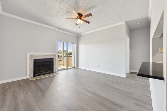 unfurnished living room featuring crown molding, a textured ceiling, and light wood-type flooring