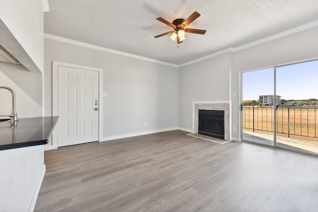 unfurnished living room featuring ornamental molding, a textured ceiling, wood-type flooring, and ceiling fan