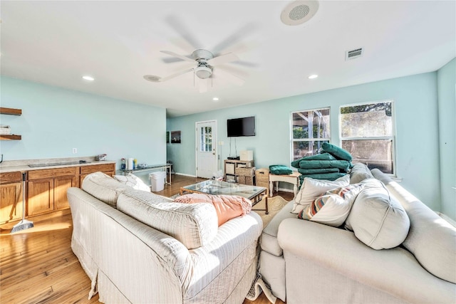 living room with light wood-type flooring and ceiling fan