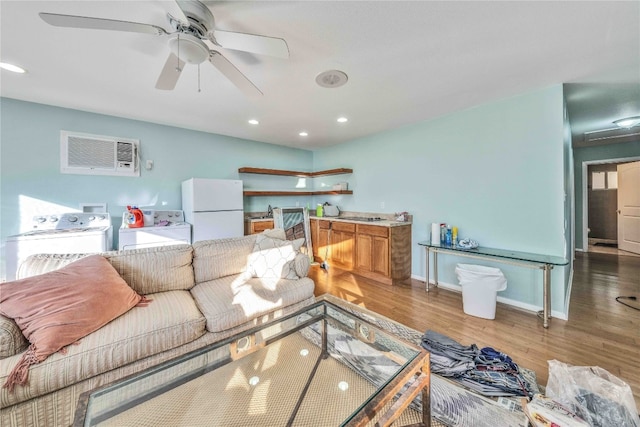 living room featuring ceiling fan, washing machine and dryer, and hardwood / wood-style floors