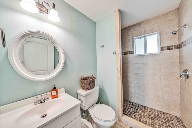 bathroom featuring vanity, toilet, and tiled shower