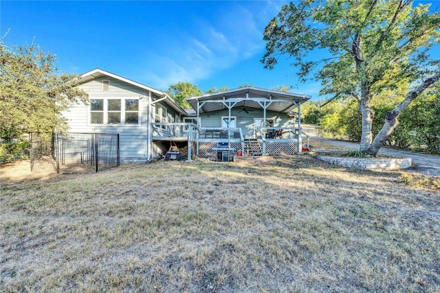 back of house with a wooden deck and a lawn