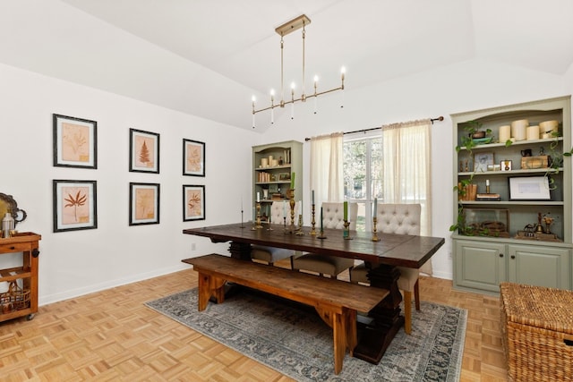 dining room featuring an inviting chandelier, lofted ceiling, and light parquet floors