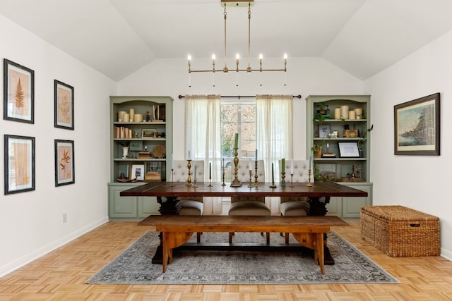 dining area featuring a notable chandelier, light parquet flooring, and vaulted ceiling