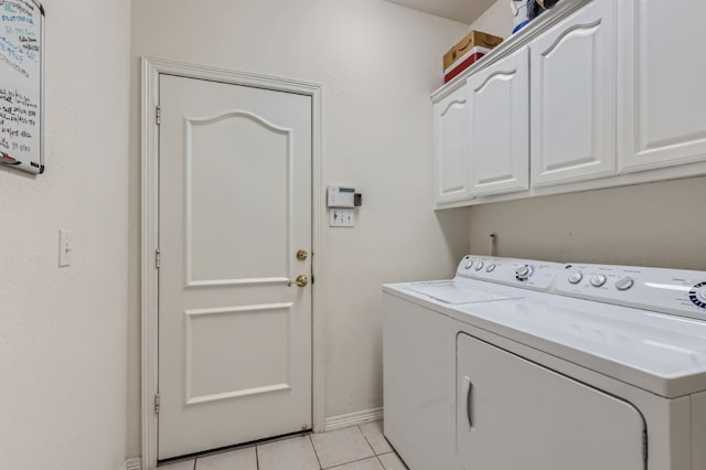 laundry room featuring cabinets, light tile patterned flooring, and separate washer and dryer