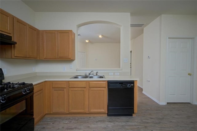 kitchen with sink, black appliances, and light wood-type flooring