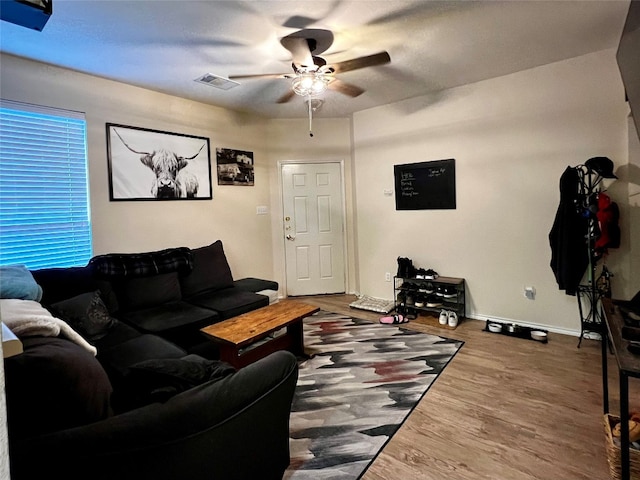 living room featuring dark wood-type flooring and ceiling fan