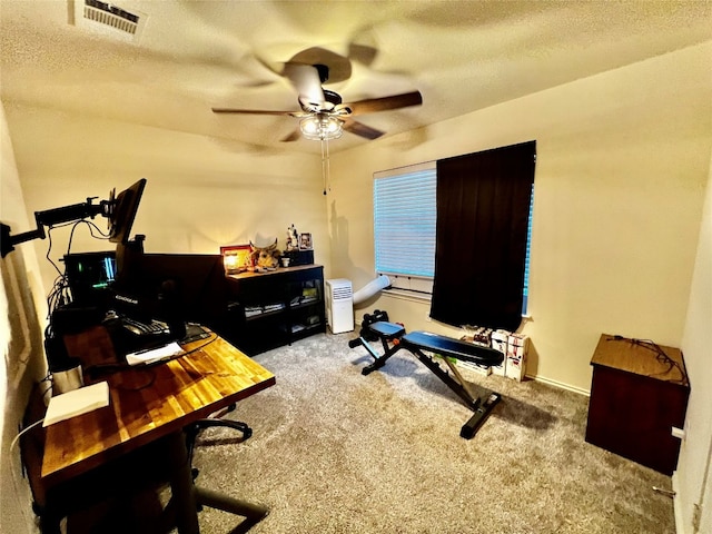 office area featuring a textured ceiling, carpet, and ceiling fan