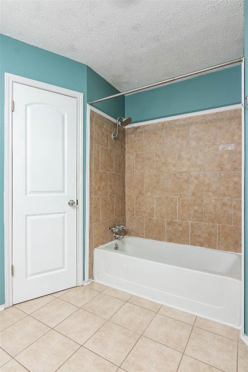full bath featuring tile patterned floors, shower / tub combination, and a textured ceiling