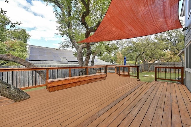 wooden terrace featuring a fenced backyard and a lawn