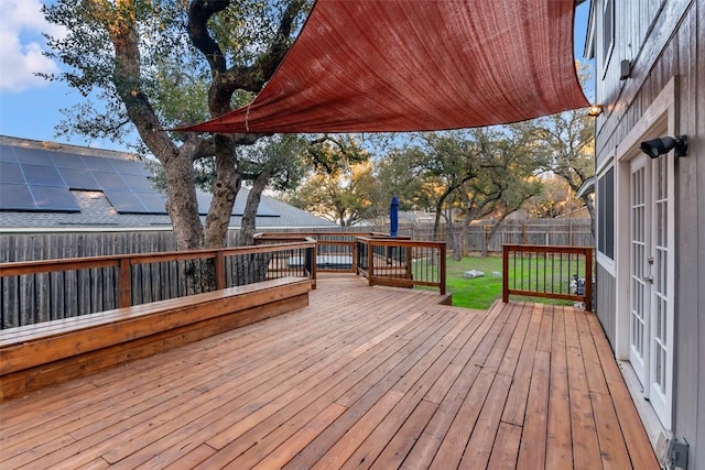 deck with a fenced backyard and a lawn