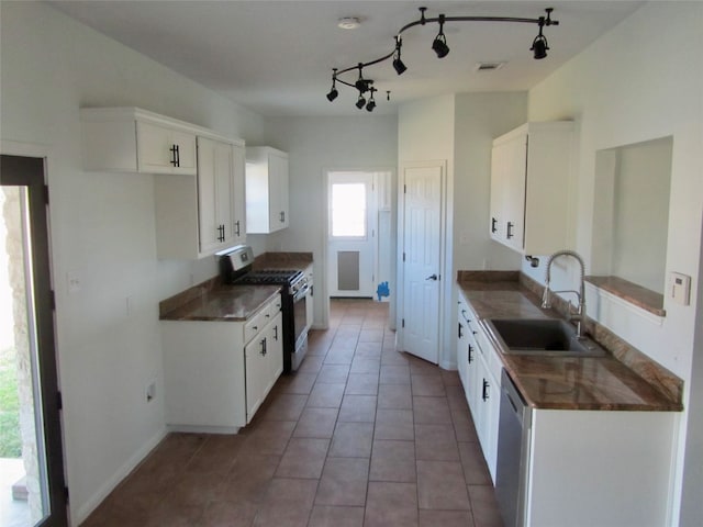 kitchen featuring rail lighting, white cabinetry, stainless steel gas stove, sink, and tile patterned flooring