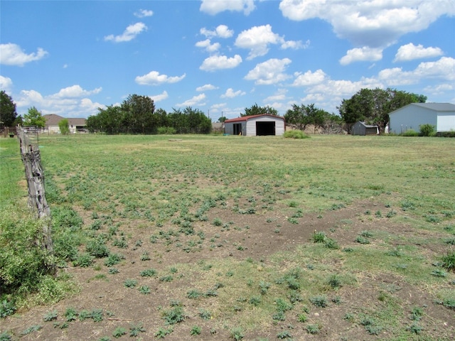 view of yard with a rural view and an outdoor structure