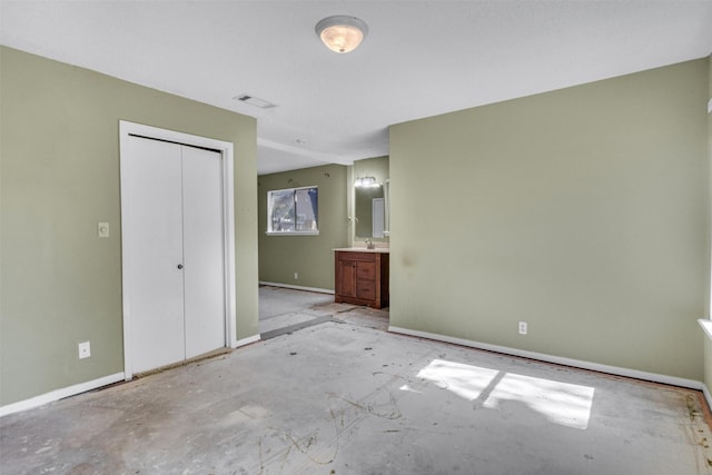 unfurnished bedroom with sink, ensuite bathroom, and a closet