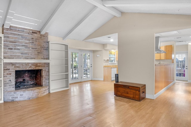 unfurnished living room with a brick fireplace, plenty of natural light, built in shelves, and lofted ceiling with beams